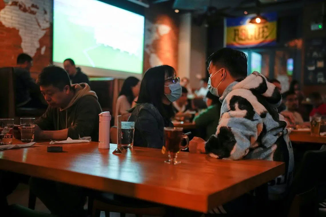 People at a bar during the World Cup match between England and Iran match in Shanghai on Nov 21, 2022.