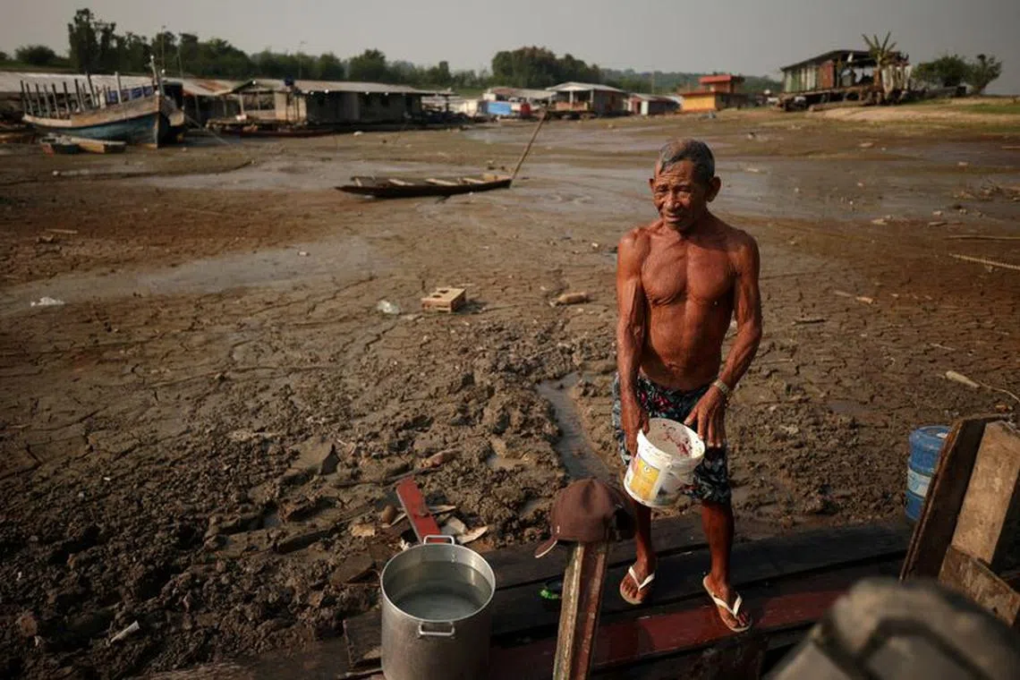 FILE PHOTO: Fisherman Raimundo da Silva do Carmo, 67, collects water from a well on Puraquequara Lake, which has been affected by drought, in Manaus, Brazil, October 6, 2023. REUTERS/Bruno Kelly/File Photo