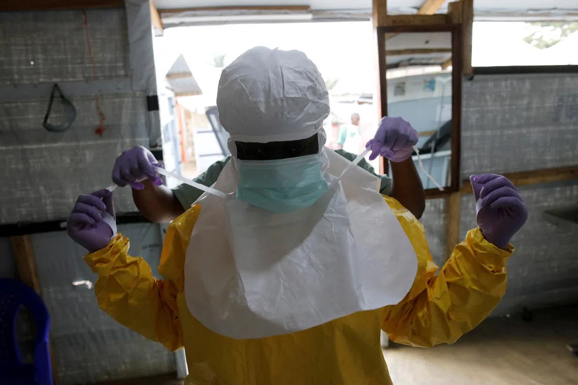 FILE PHOTO: A health worker puts on Ebola protection gear before entering the Biosecure Emergency Care Unit (CUBE) at the ALIMA (The Alliance for International Medical Action) Ebola treatment centre in Beni, in the Democratic Republic of Congo, March 31, 2019. Picture taken March 31, 2019. REUTERS/Baz Ratner/File Photo