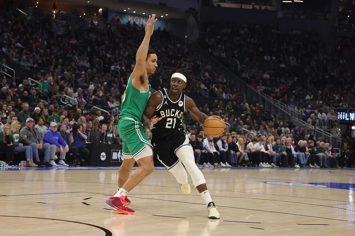 Jrue Holiday of the Milwaukee Bucks is defended by Malcolm Brogdon of the Boston Celtics during the first half at Fiserv Forum on Feb 14, 2023.
