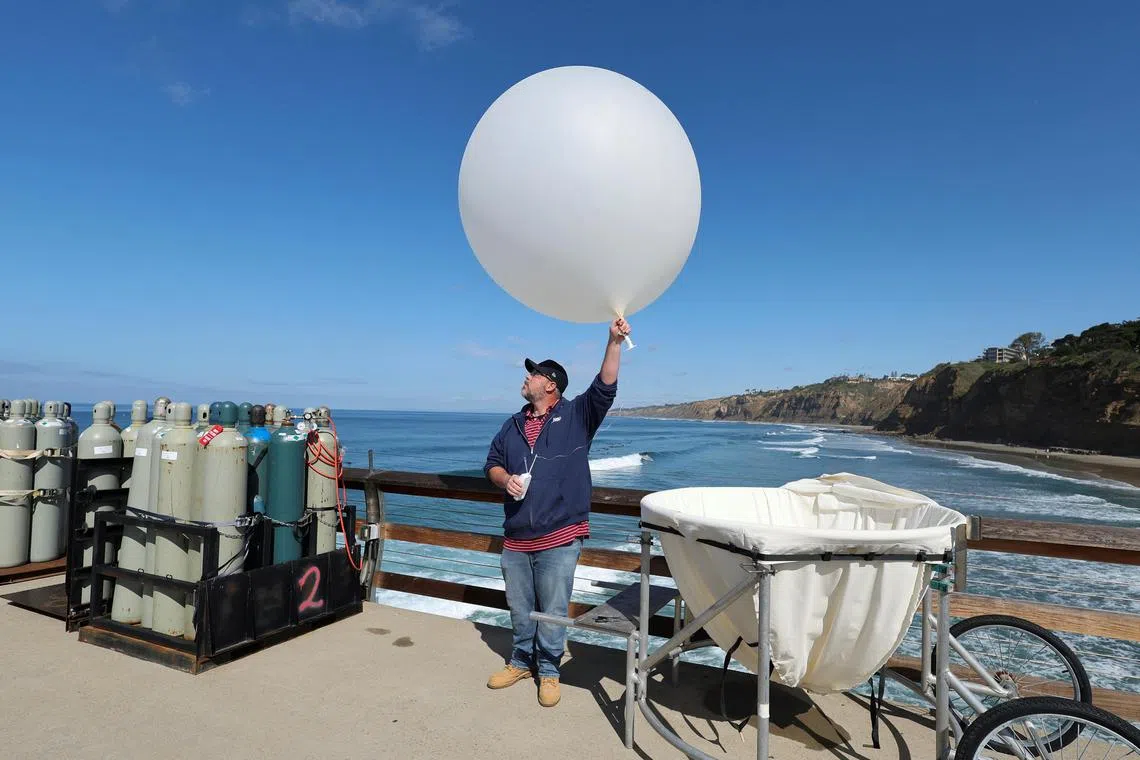 A man launching a science balloon in San Diego, California, on Feb 13, as part of a climate science experiment in collaboration with the US Department of Energy and other groups.