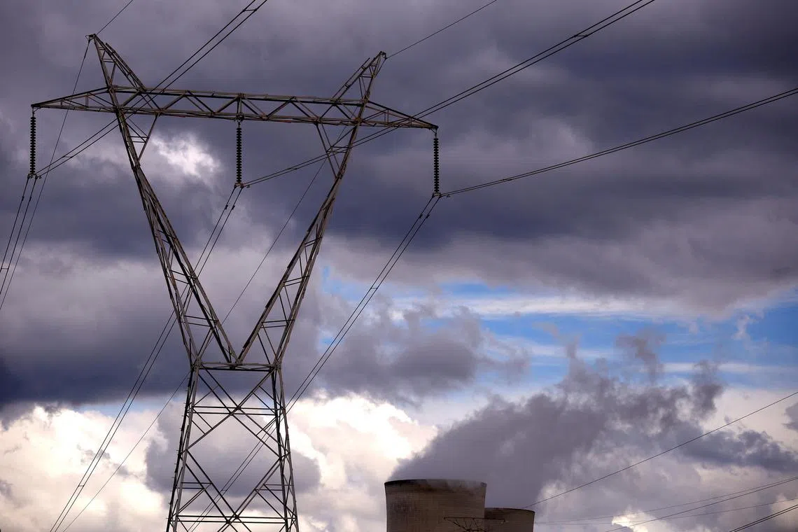 FILE PHOTO: Power lines and storm clouds can be seen above the Bayswater coal-powered thermal power station located near the central New South Wales town of Muswellbrook, Australia March 14, 2017. REUTERS/David Gray/File Photo