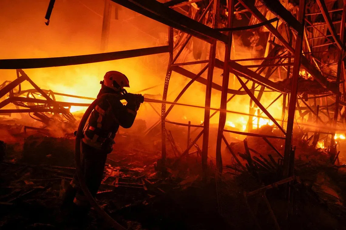 A firefighter works at a compound of a warehouse damaged during Russian missile strikes, amid Russia's attack on Ukraine, in Kyiv, Ukraine July 16, 2026. REUTERS/Valentyn Ogirenko TPX IMAGES OF THE DAY
