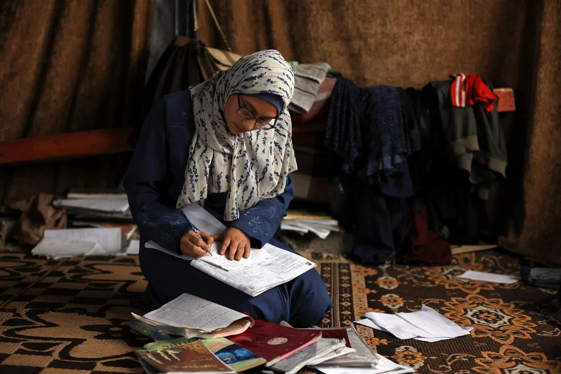 Displaced 19-year-old Palestinian student of Gaza's Azhar Institute, Saja Adwan, studies at a damaged school building being used as a shelter for displaced families, in Gaza City, May 28, 2025. REUTERS/Dawoud Abu Alkas