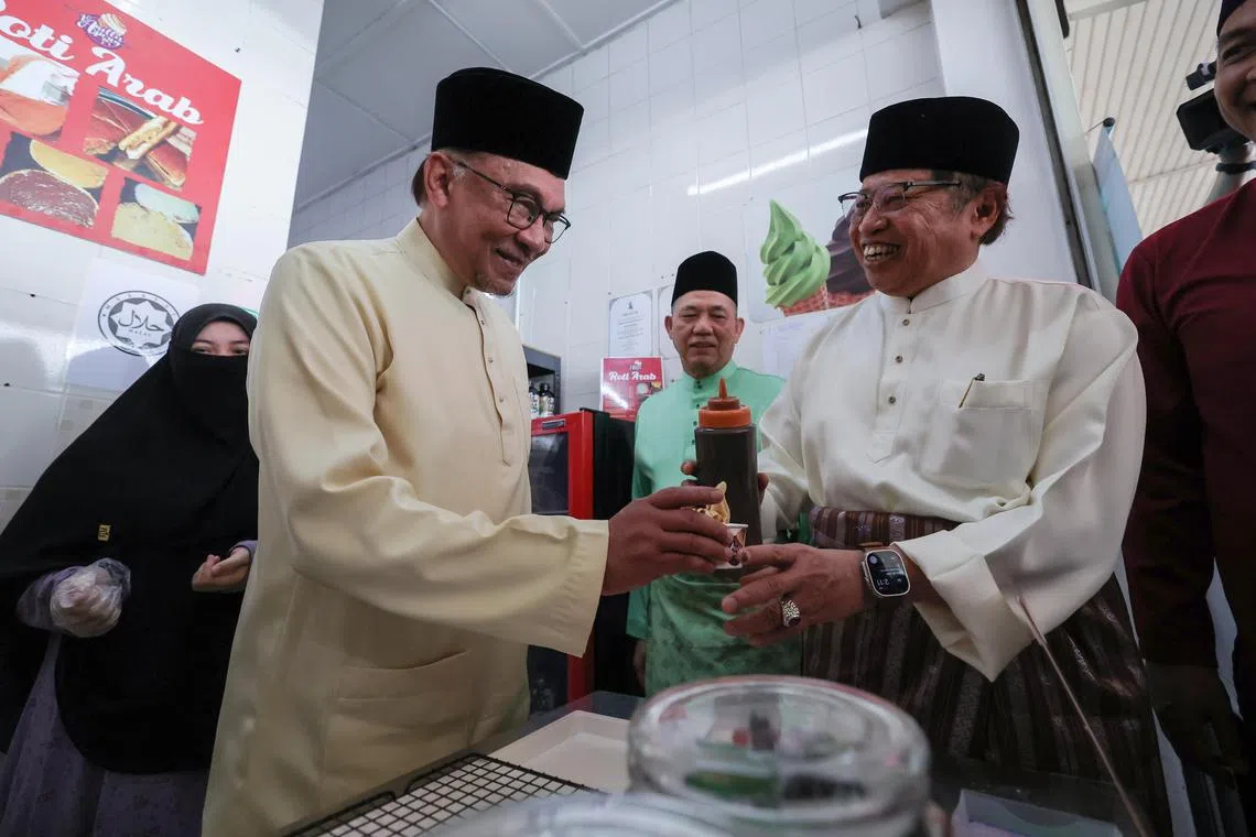 Malaysia PM Anwar (left) and Sarawak Premier Abang Johari attending an event, during the prime minister's visit to the East Malaysian region on Friday. 