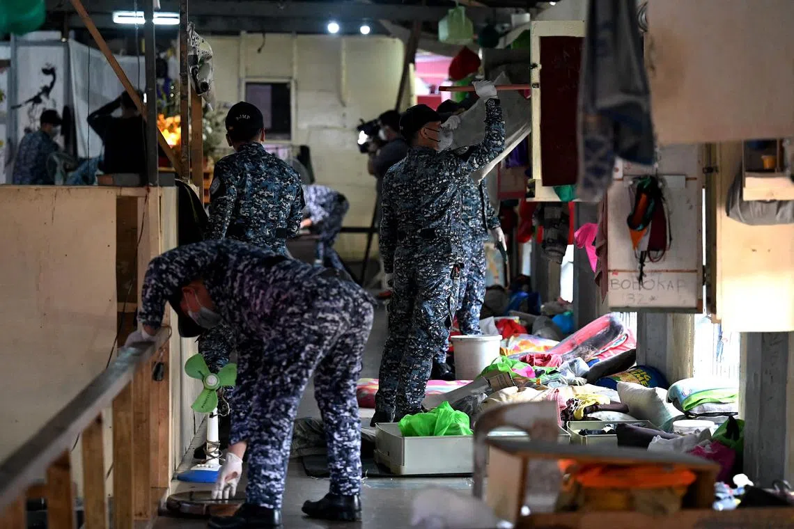 Police officers inspect the belongings of prison inmates during a search operation for contraband and illegal drugs in Oct, 2022.