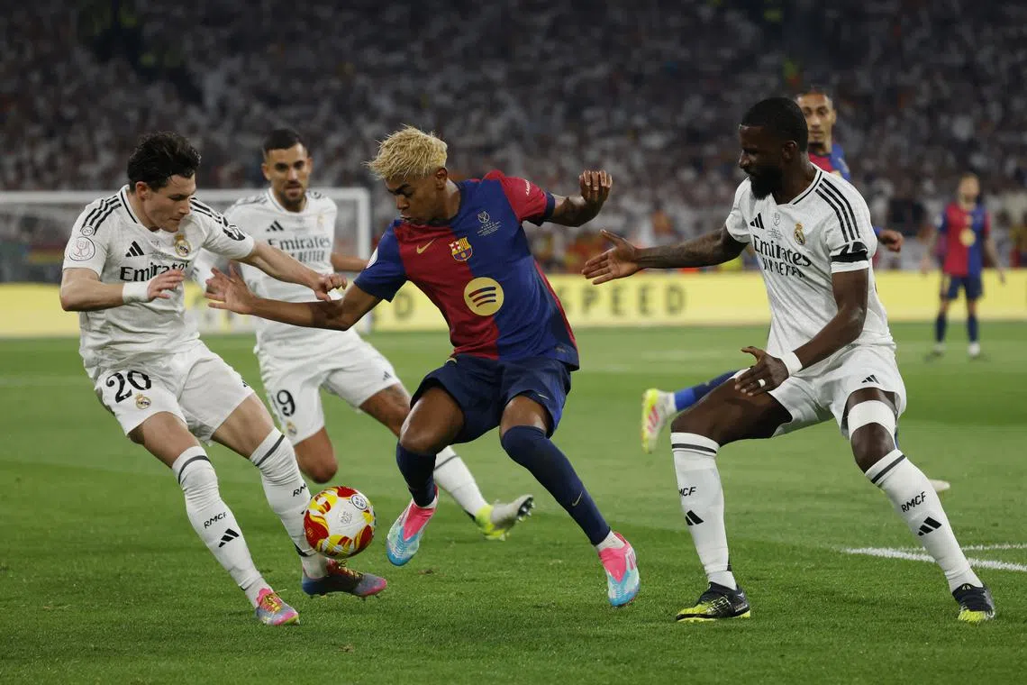 FILE PHOTO: Soccer Football - Copa del Rey - Final - FC Barcelona v Real Madrid - Estadio de La Cartuja, Seville, Spain - April 26, 2025 FC Barcelona's Lamine Yamal in action with Real Madrid's Fran Garcia and Antonio Rudiger REUTERS/Marcelo Del Pozo/File Photo