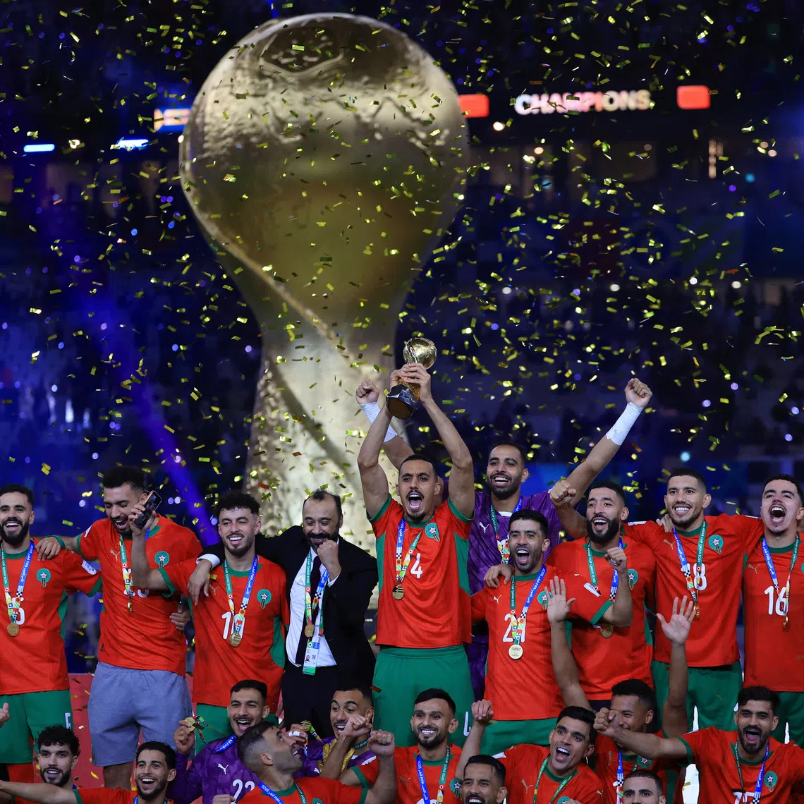Soccer Football - FIFA Arab Cup - Qatar 2025 - Final - Jordan v Morocco - Lusail Stadium, Lusail, Qatar - December 18, 2025 Morocco players and coach Tarik Sektioui celebrate on the podium as Soufiane Bouftini lifts the trophy REUTERS/Thaier Al-Sudani