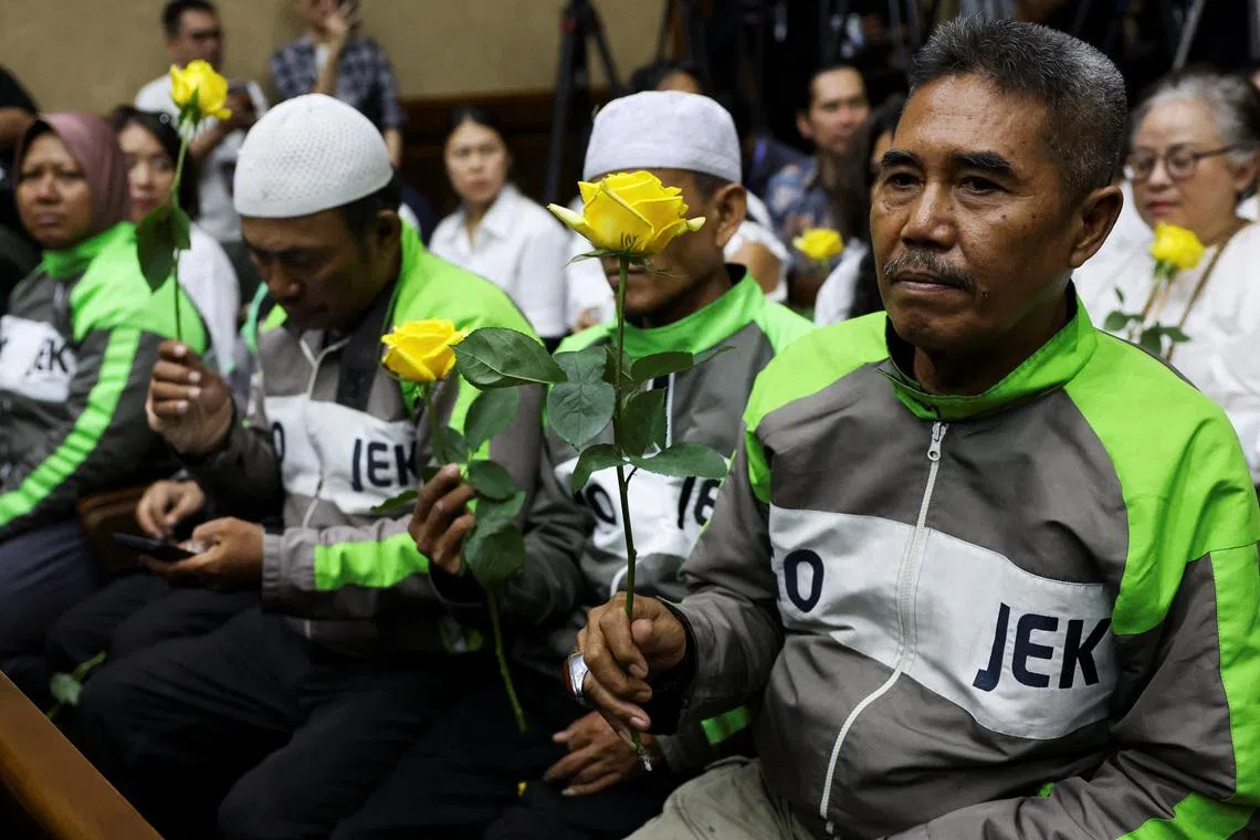 Supporters hold roses in the courtroom on the day of the verdict in a corruption case against Nadiem Makarim, who is accused by prosecutors of using his executive powers to enrich himself.