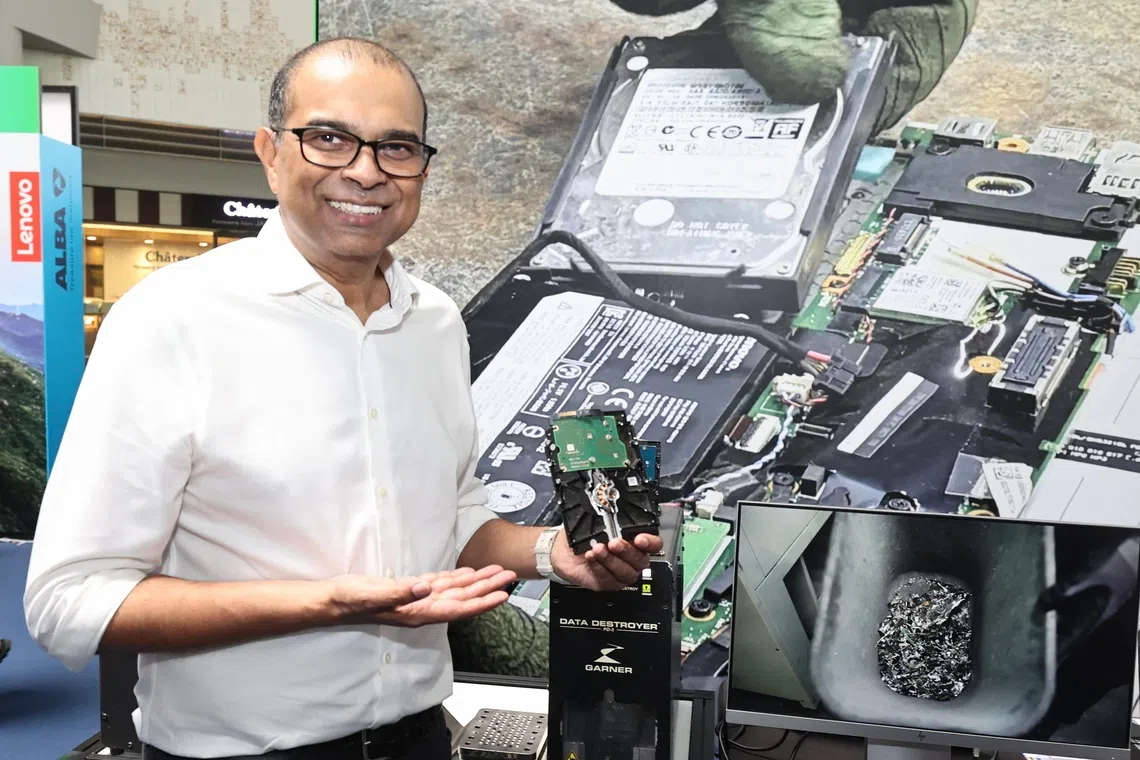 CMG20261010-ChewKW01 / 周国威 / 周岳翔 / International E-Waste Day 2026 、 GOH is Dr Janil Puthucheary, Ministry of Sustainability and the Environment and Ministry of Education ( Kampong Admiralty ). . SMS Janil holding up a crushed and destroyed hard disk that he just help to process the hard disk