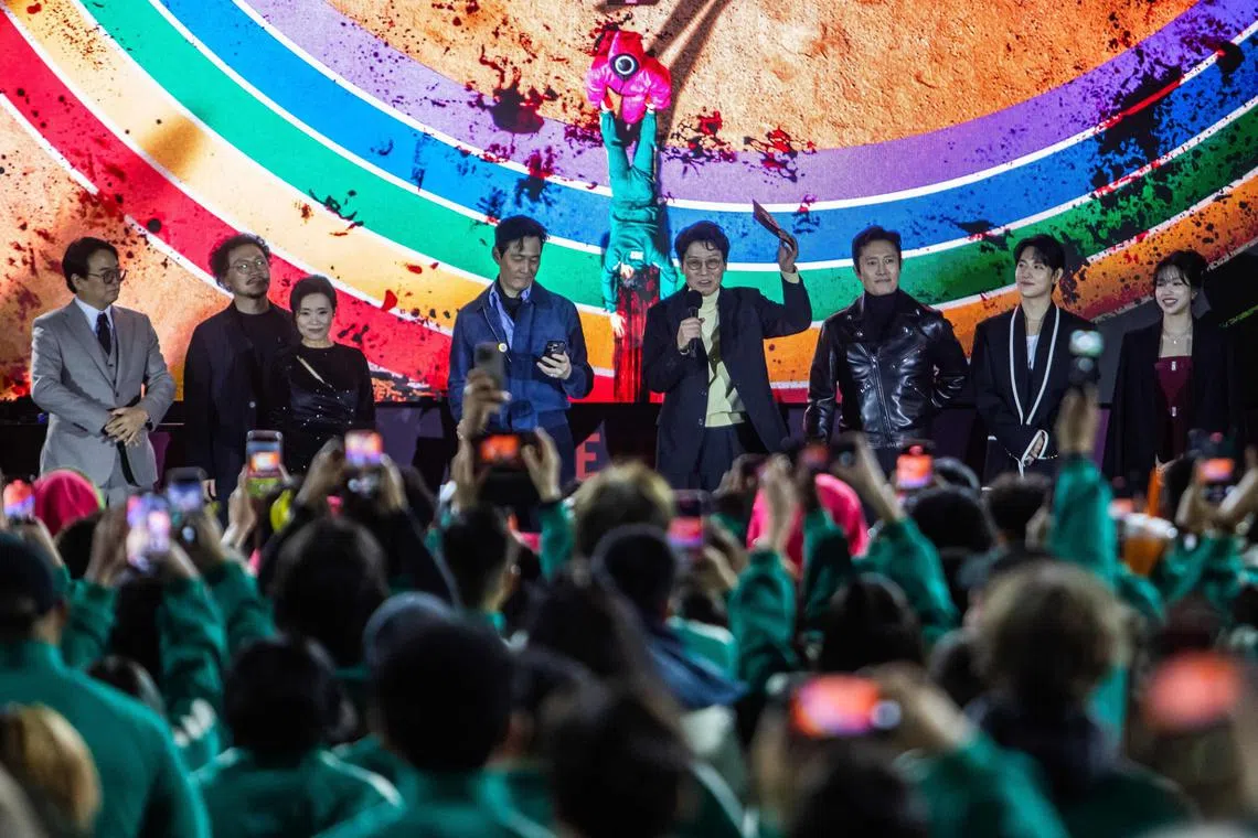 South Korean director Hwang Dong-hyuk (C) speaks onstage during Netflix's "Squid Game: Season 2" LA premiere and fan event at Los Angeles City College on December 12, 2024. (Photo by Apu GOMES / AFP)