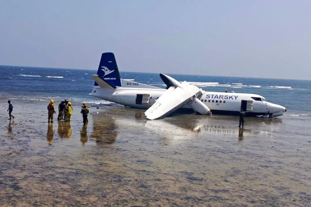 Rescuers standing near a plane that crashed on the seashore in Mogadishu, Somalia on Feb 10, 2026. 