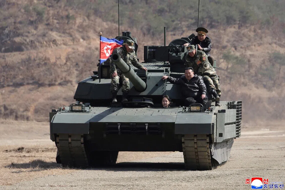North Korean leader Kim Jong Un and his daughter Kim Ju Ae ride a tank during what North Korean state news agency KCNA reports is an offensive tactical drill involving a new type of tank, at a training base in Pyongyang, North Korea, March 19, 2026, in this picture released by North Korea's official Korean Central News Agency. KCNA via REUTERS