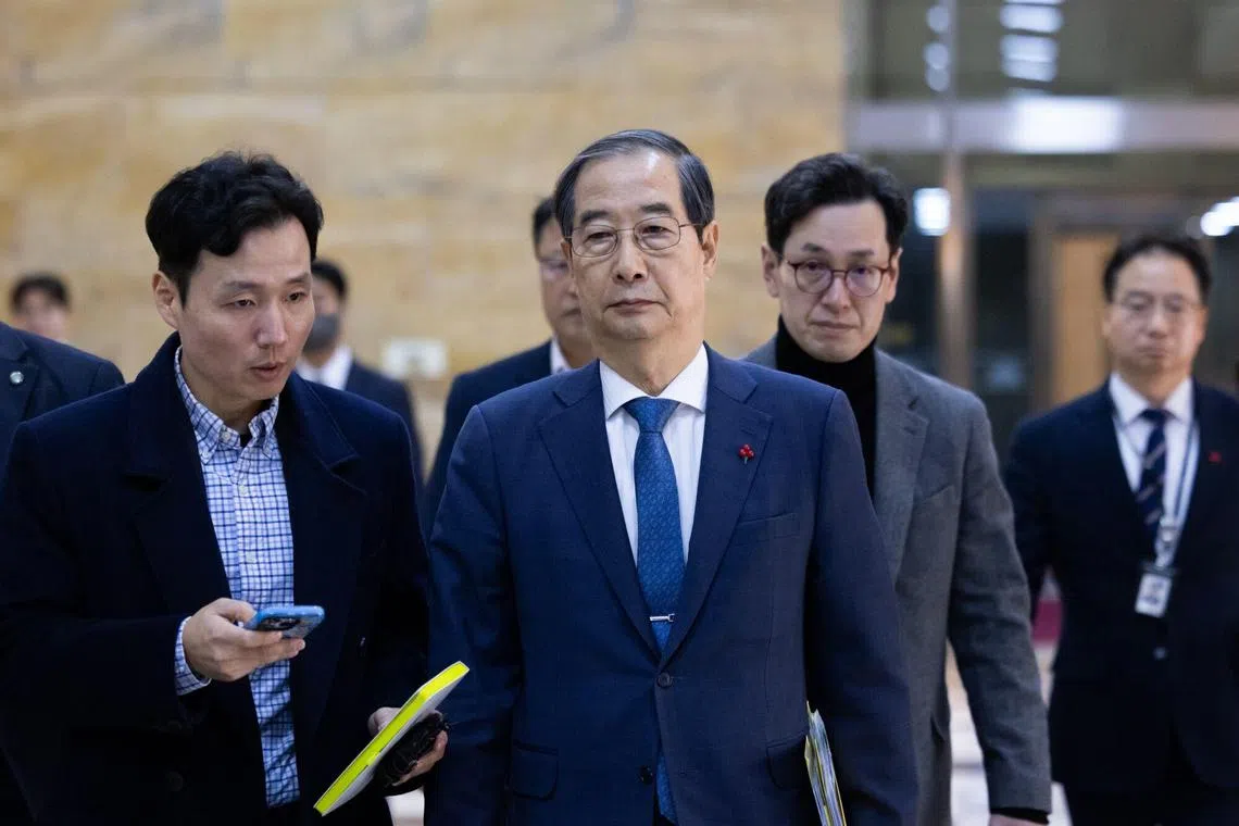 South Korea's Prime Minister Han Duck-soo (center) will serve as acting president for up to six months.