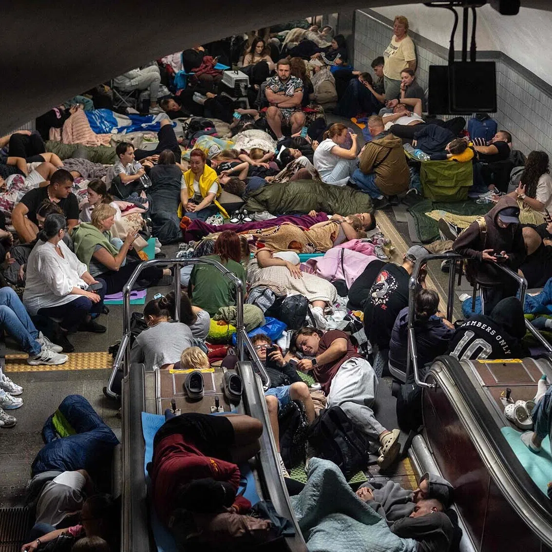 TOPSHOT - People take shelter at a metro station during Russian missile strike on Kyiv, early on July 30, 2026, amid the Russian invasion of Ukraine. Russian strikes on Kyiv killed at least one person, authorities said on July 30, after Ukrainian President Volodymyr Zelensky warned of Moscow launching another massive attack overnight. (Photo by OLEKSII FILIPPOV / AFP)