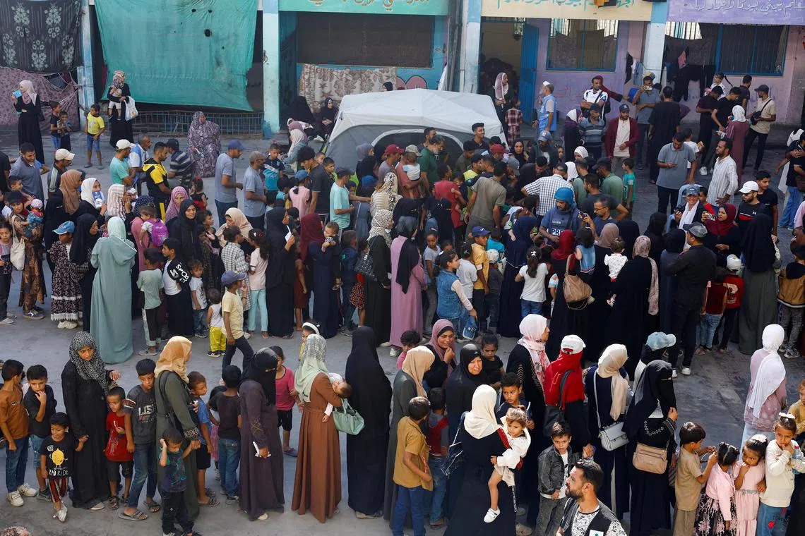 People queue as Palestinian children are vaccinated against polio, amid the Israel-Hamas conflict, in Khan Younis in the southern Gaza Strip.