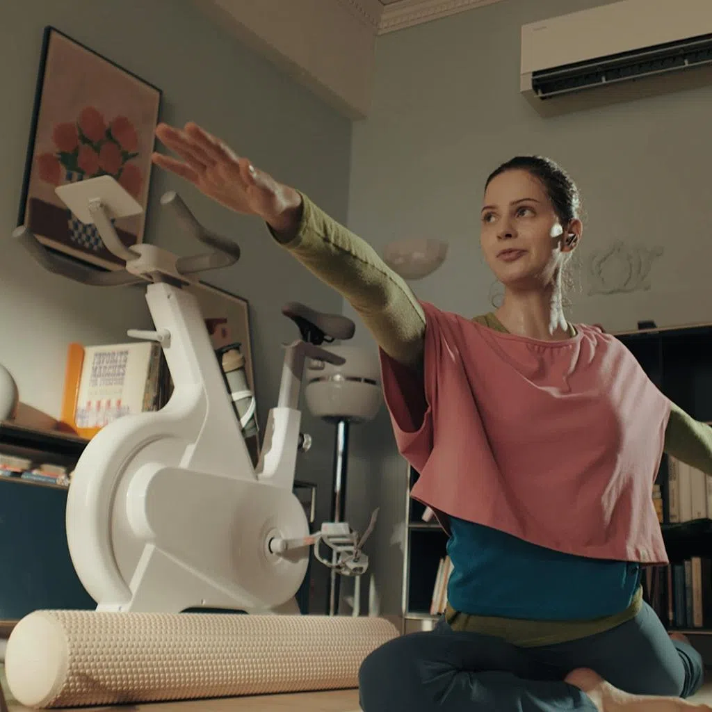 Woman doing yoga at home enjoying cool air from Samsung’s Bespoke AI WindFree Pro air-conditioner