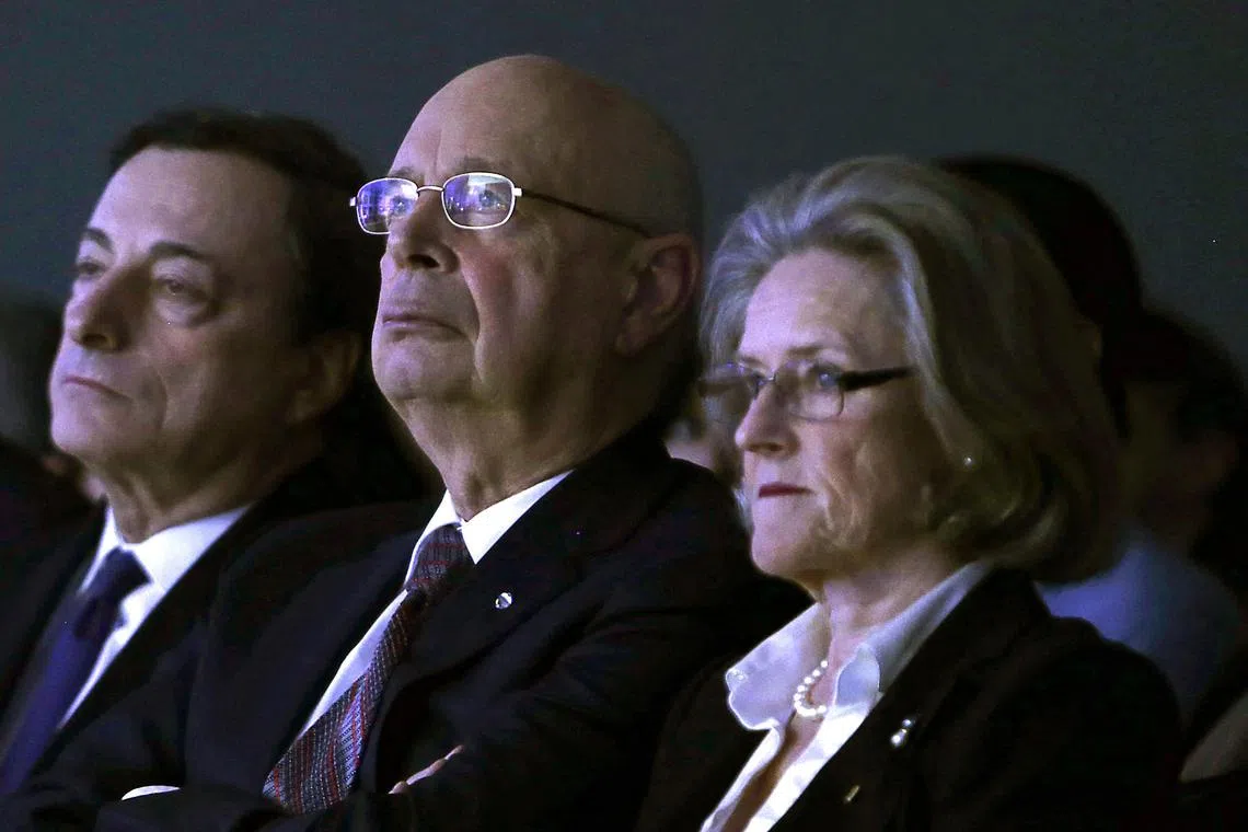 (FILES) World Economic Forum founder Klaus Schwab (C) and his wife Hilde (R) listen to a speech by the US secretary of state at the World Economic Forum in Davos on January 24, 2014. An investigation conducted by the World Economic Forum's board has cleared the body's founder Klaus Schwab and his wife of wrongdoing, after whistleblower complaints, it said on August 15, 2025. (Photo by GARY CAMERON / POOL / AFP)
