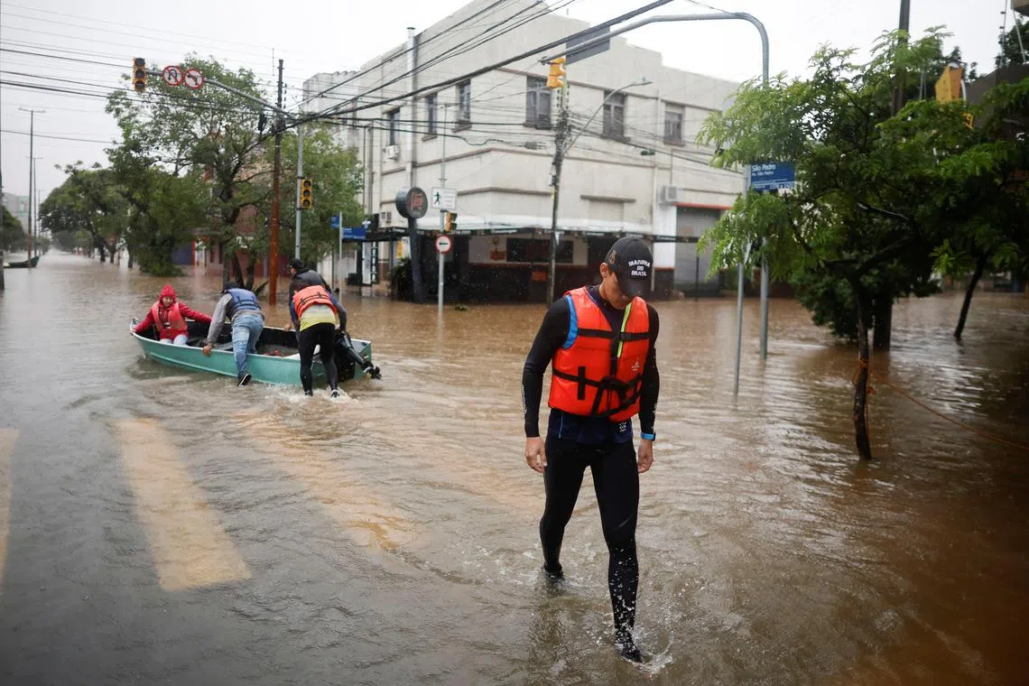 Brazilian pre-Olympic rower Piedro Tuchtenhagen walks after loading a boat used to rescue flood victims in Porto Alegre, state of Rio Grande do Sul, on May 10, 2024.