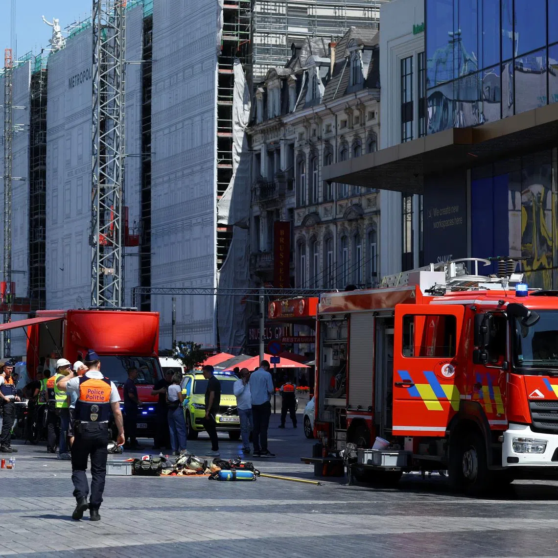 A member of the police walking near a fire truck, following a fire at Oxy Brussels building in Brussels, Belgium, on July 14.