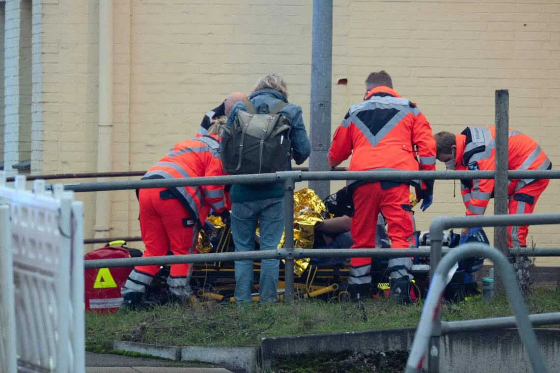 Rescue workers attend to a wounded person near a railway crossing. The suspect was taken into custody.