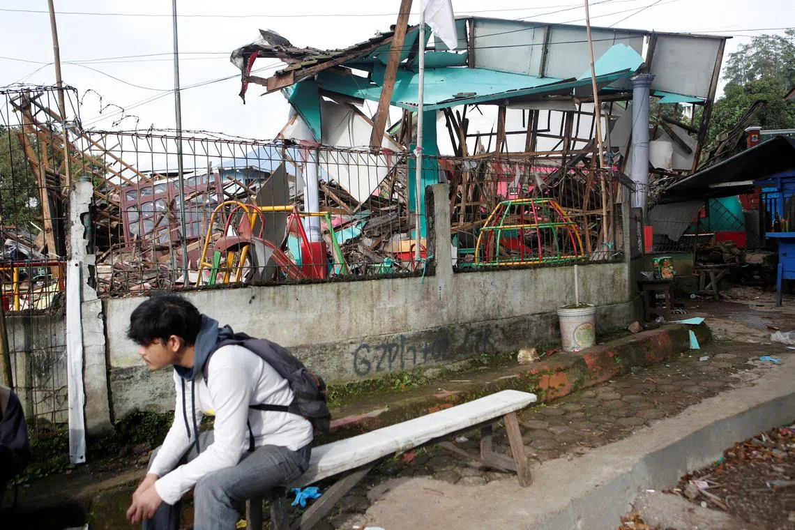 A man sits near a destroyed kindergarten affected by the earthquake in Cugenang, Cianjur, West Java province, Indonesia, Nov 22, 2022. 