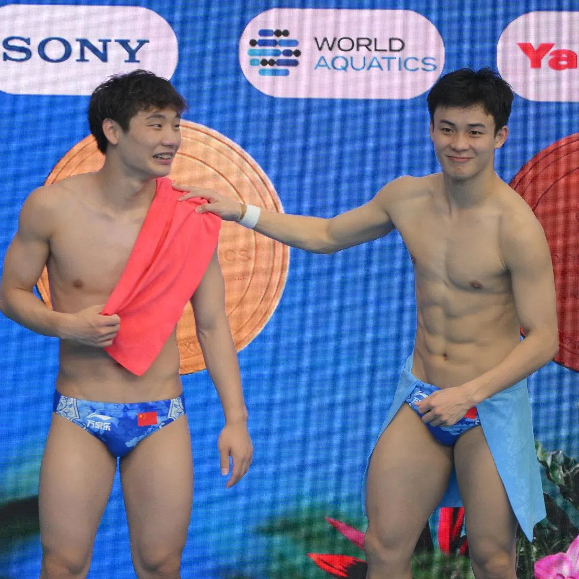 Bronze medalist Yan Siyu (right) of China congratulates his teammate Gold Medalist Zheng Jiuyuan of China after the Men's 1m Springboard final of the World Aquatic Championship held at the OCBC Aquatic Centre on July 27, 2025.