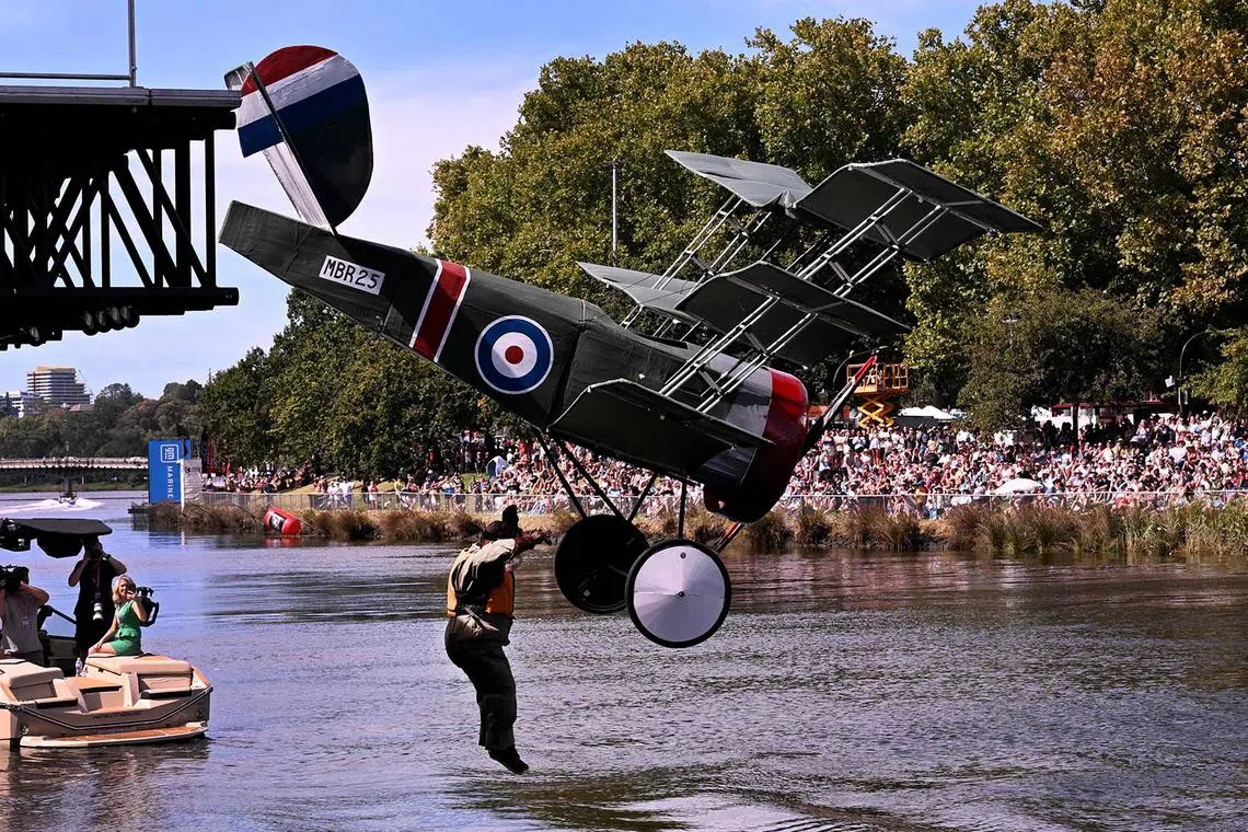 TOPSHOT - A competitor leaps into the Yarra River during the annual Moomba Festival Birdman Rally where entrants raise money for charity with their flying machine in Melbourne on March 9, 2025. (Photo by William WEST / AFP)