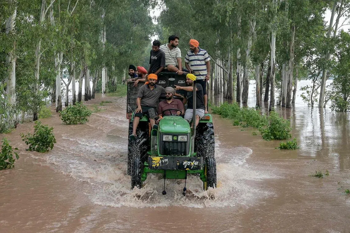 Residents rescuing victims stuck in a flooded area using a tractor after a rise in water level of the Ravi river following heavy rains at a village near Ramdas, India, on Aug 28, 2025. 