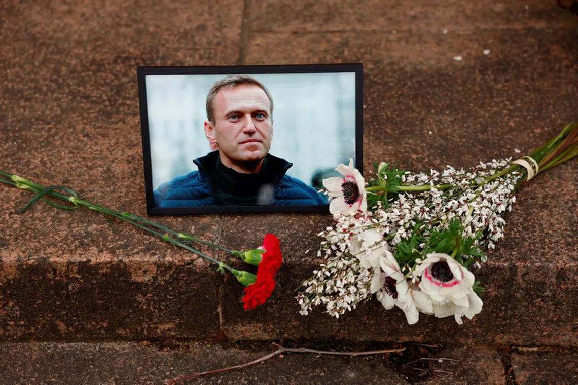 Flowers and a portrait of Russian opposition leader Alexei Navalny are seen following Navalny's death, as people gather near the Russian embassy in Paris, France, Feb 16, 2024.