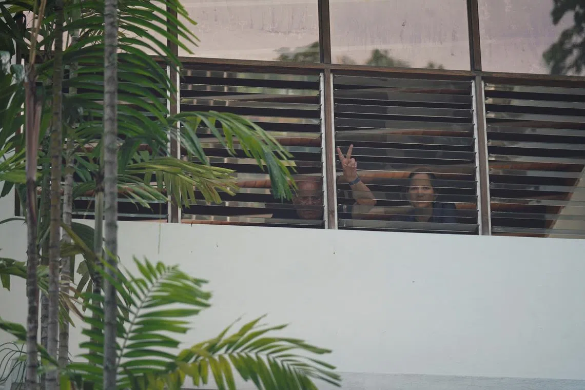 People react to the camera from inside the Argentinian embassy in Caracas, Venezuela July 31, 2024. REUTERS/Alexandre Meneghini