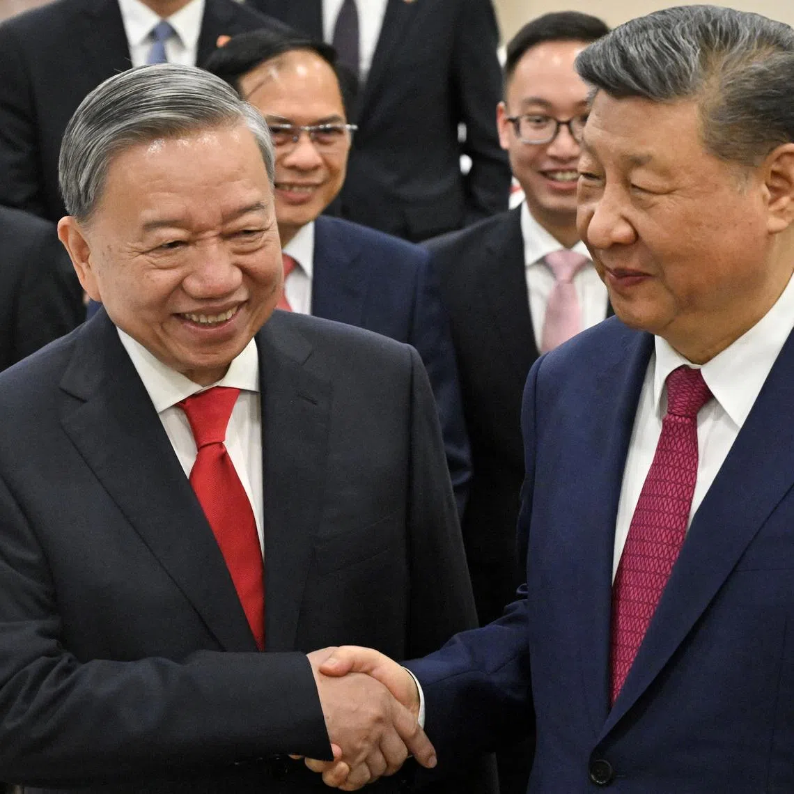 Vietnam's Communist Party General Secretary To Lam and China's President Xi Jinping shake hands as they view copies of agreements signed between China and Vietnam following their meeting at the office of the Party Central Committee in Hanoi on April 14, 2025. NHAC NGUYEN/Pool via REUTERS
