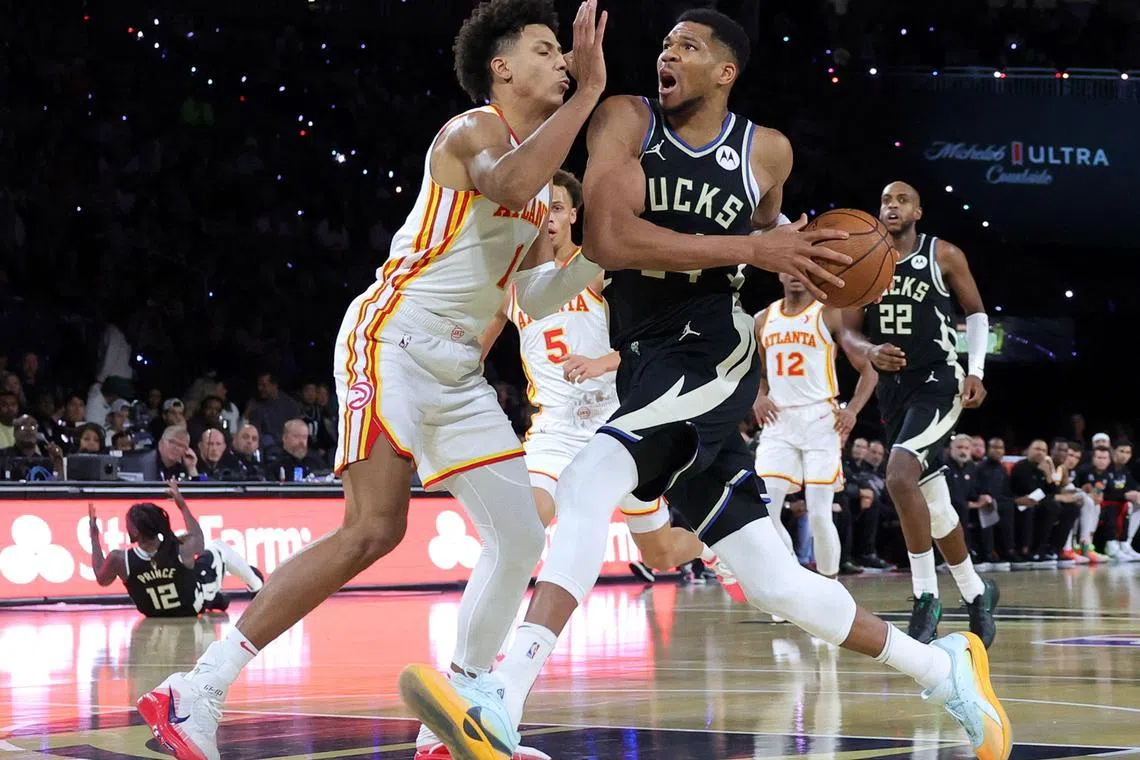 Giannis Antetokounmpo #of the Milwaukee Bucks drives against Jalen Johnson of the Atlanta Hawks in the first half at T-Mobile Arena.