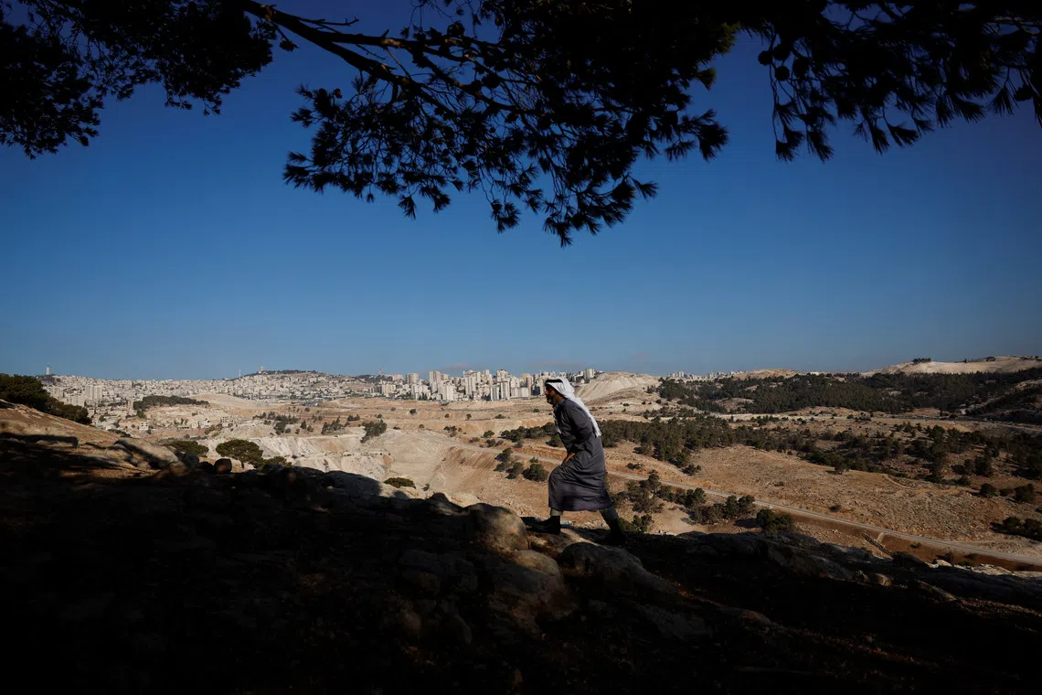 A Palestinian Bedouin walks up a hill, as the communities of Jabal Al-Baba faces displacement due to plans to build a new Israeli settlement near the E1 road, in Jabal Al-Baba in the Israeli-occupied West Bank, September 17, 2025. REUTERS/Ammar Awad