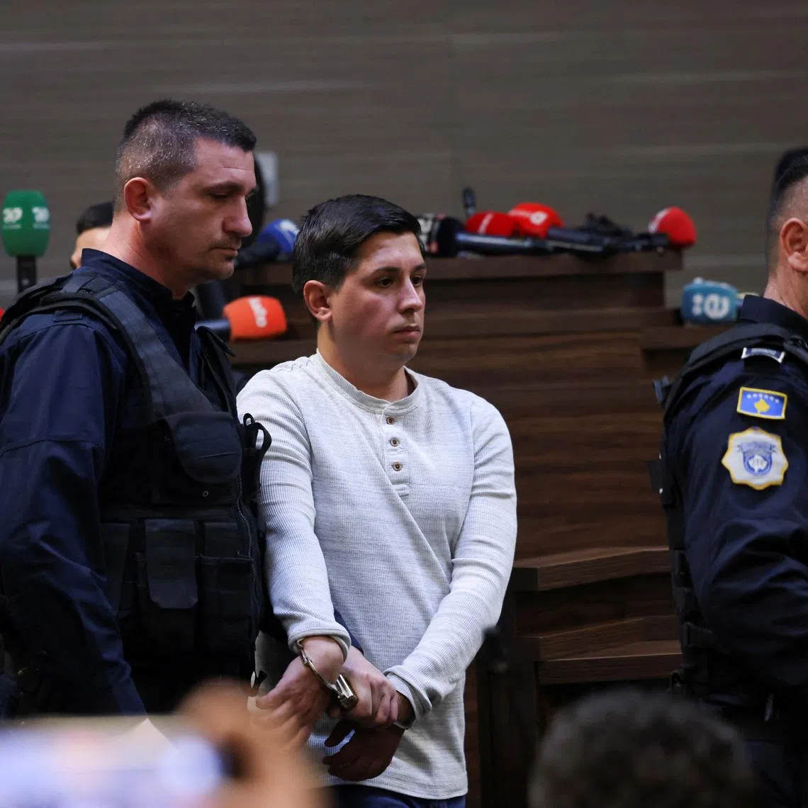 Kosovo police officers escort Dusan Maksimovic after he was sentenced to 30 years in prison, at the court in Pristina, Kosovo April 24, 2026. REUTERS/Valdrin Xhemaj