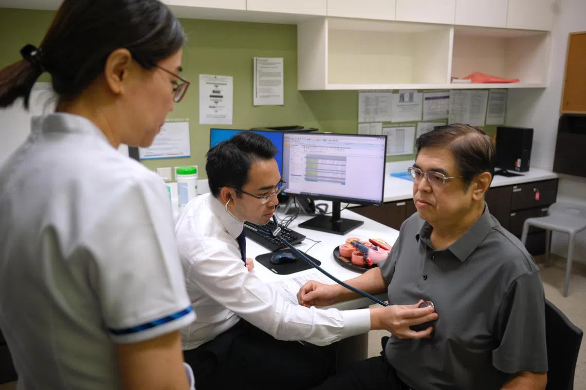 In this mock-up, Associate Professor Kenneth Chew (centre) , consultant, Department of Cardiology, National Heart Centre Singapore (NHCS), checks 63-year-old patient Lam Theam Fatt (right), with Ivy Tan, Senior Staff Nurse and Care Coordinator, NHCS, on Jan 20, 2025.
