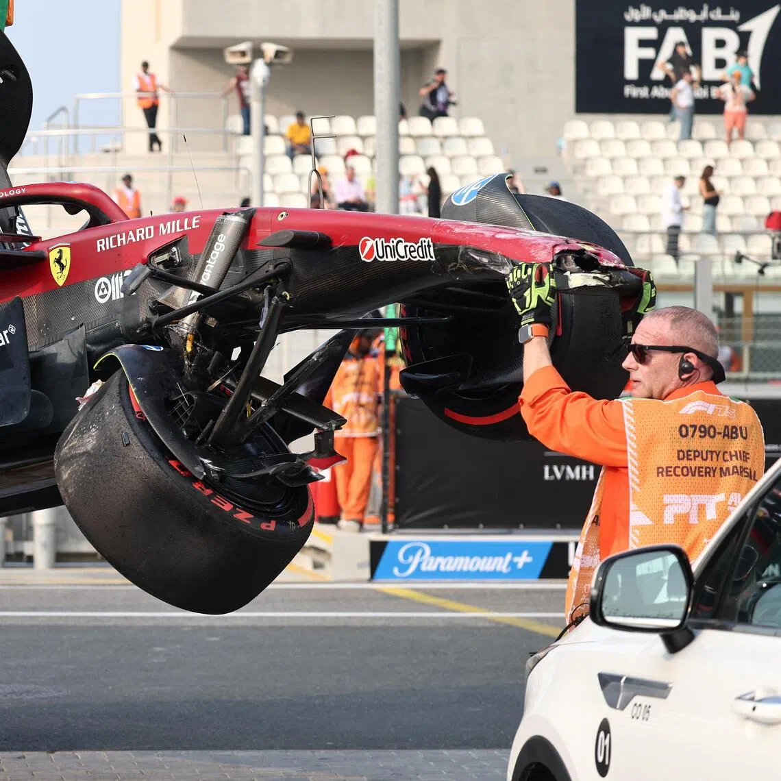 Stewards retrieving the car of Ferrari's Lewis Hamilton after his crash during practice.