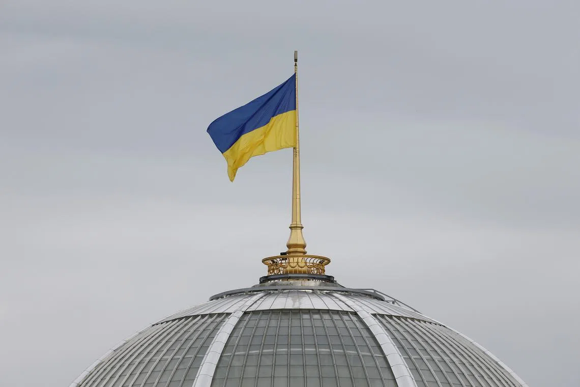 FILE PHOTO: A Ukrainian state flag, which is installed on the roof of the parliament building, flies in Kiev, Ukraine September 25, 2019. REUTERS/Valentyn Ogirenko/File photo