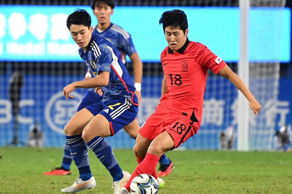 South Korea's Lee Kang-in (#18) fights for the ball with Japan's Hayato Okuda (#2) in the men's football gold medal match on Oct 7, 2023.