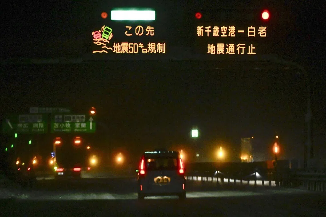 A sign displays information about a road closure due to an earthquake on a highway in Chitose, Hokkaido.