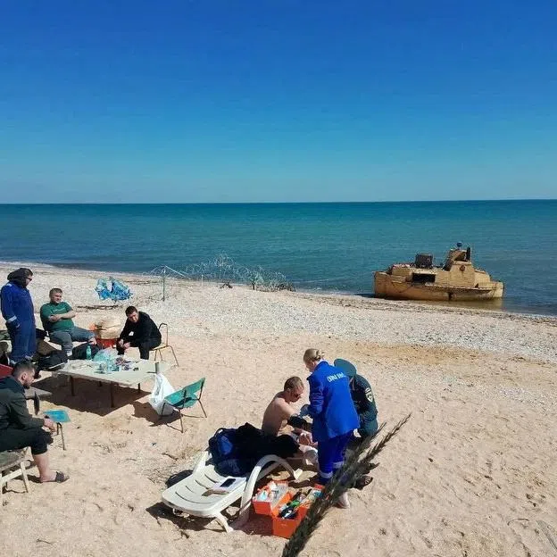 Rescued members of a dry cargo ship, which sank in the Sea of ​​Azov, according to local authorities, are assisted on the coast of the Russian-controlled part of the Kherson region, Ukraine, in this picture released on April 5, 2026. Vladimir Saldo, leader of the Russian-controlled parts of Kherson region via Telegram/Handout via REUTERS