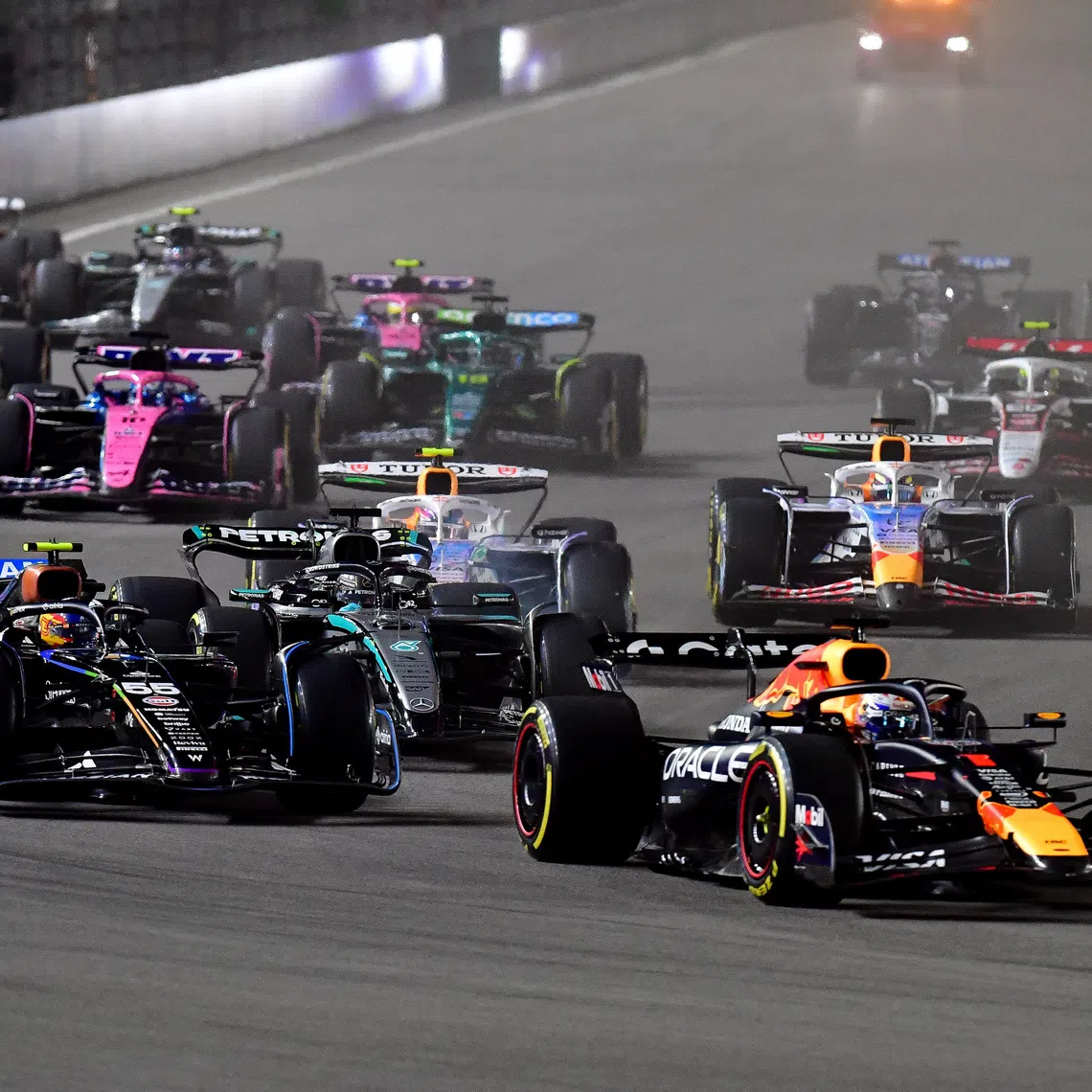 Nov 21, 2025; Las Vegas, NV, USA; Red Bull Racing driver Max Verstappen (1) leads Williams driver Carlos Sainz (55) and the rest of the field during the opening laps of the Las Vegas Grand Prix at Las Vegas Strip Circuit. Gary A. Vasquez-Imagn Images
