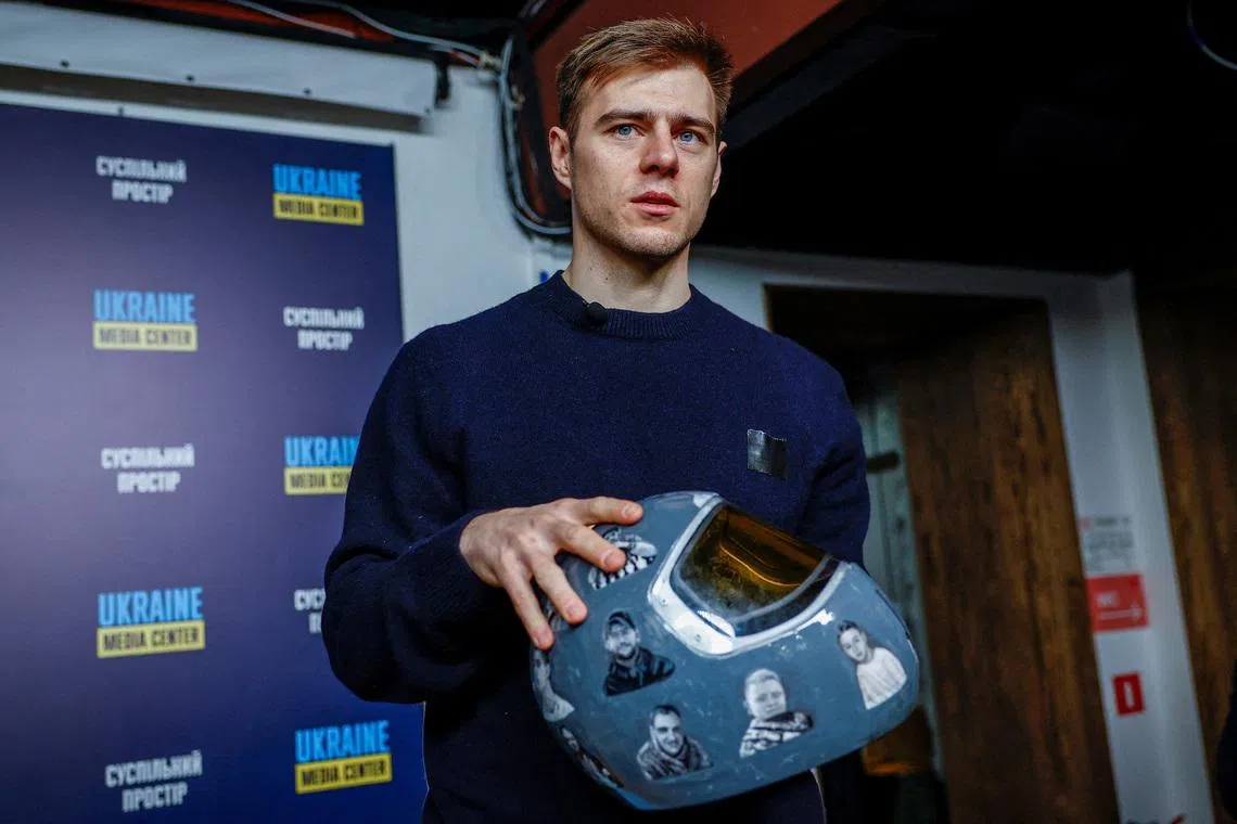 Vladyslav Heraskevych, a Ukrainian skeleton racer, holds his helmet with images depicting athletes killed since the start of Russia's invasion of Ukraine, during a press conference after he was disqualified from the Milano Cortina 2026 Winter Olympic Games for wearing it, in Kyiv, Ukraine, February 19, 2026. REUTERS/Alina Smutko