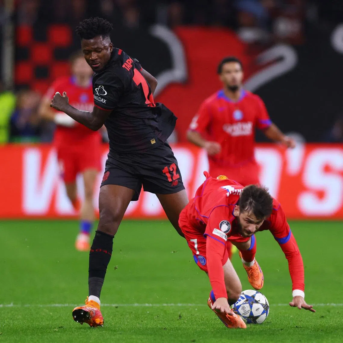 FILE PHOTO: Soccer Football - UEFA Champions League - Bayer Leverkusen v Paris St Germain - BayArena, Leverkusen, Germany - October 21, 2025 Bayer Leverkusen's Edmond Tapsoba in action with Paris St Germain's Khvicha Kvaratskhelia REUTERS/Thilo Schmuelgen/ File Photo
