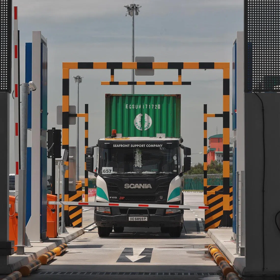 A container truck about to pass through the Radiographic Scanning Portal at Tuas Port on 18 Apr 2022. Immigration and Checkpoints Authority (ICA) has been progressively implementing new initiatives at Tuas Port, with the aim of providing visitors with a seamless and more secure cargo clearance experience. The radiographic scanning portal scans cargo for anomalies as vehicles go through it.
