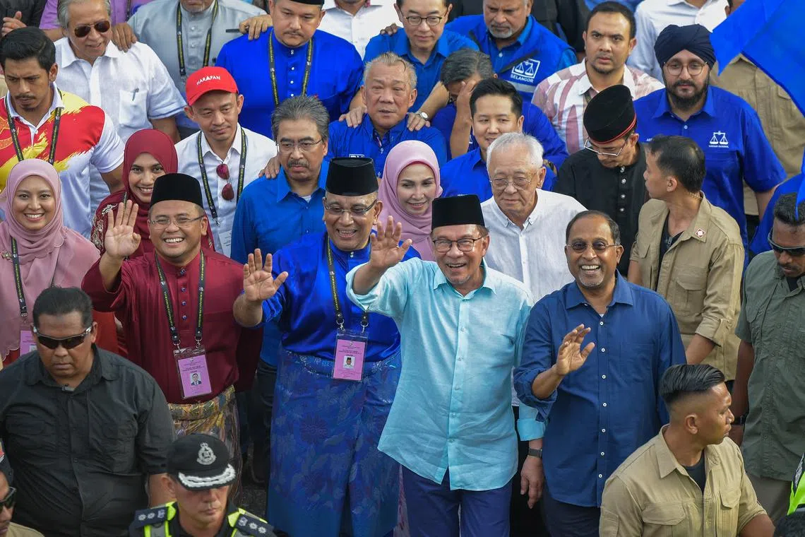 Malaysian PM Anwar Ibrahim (in light blue), accompanied by election candidates and leaders of his PH-BN alliance, at the Gombak nomination centre in Selangor.