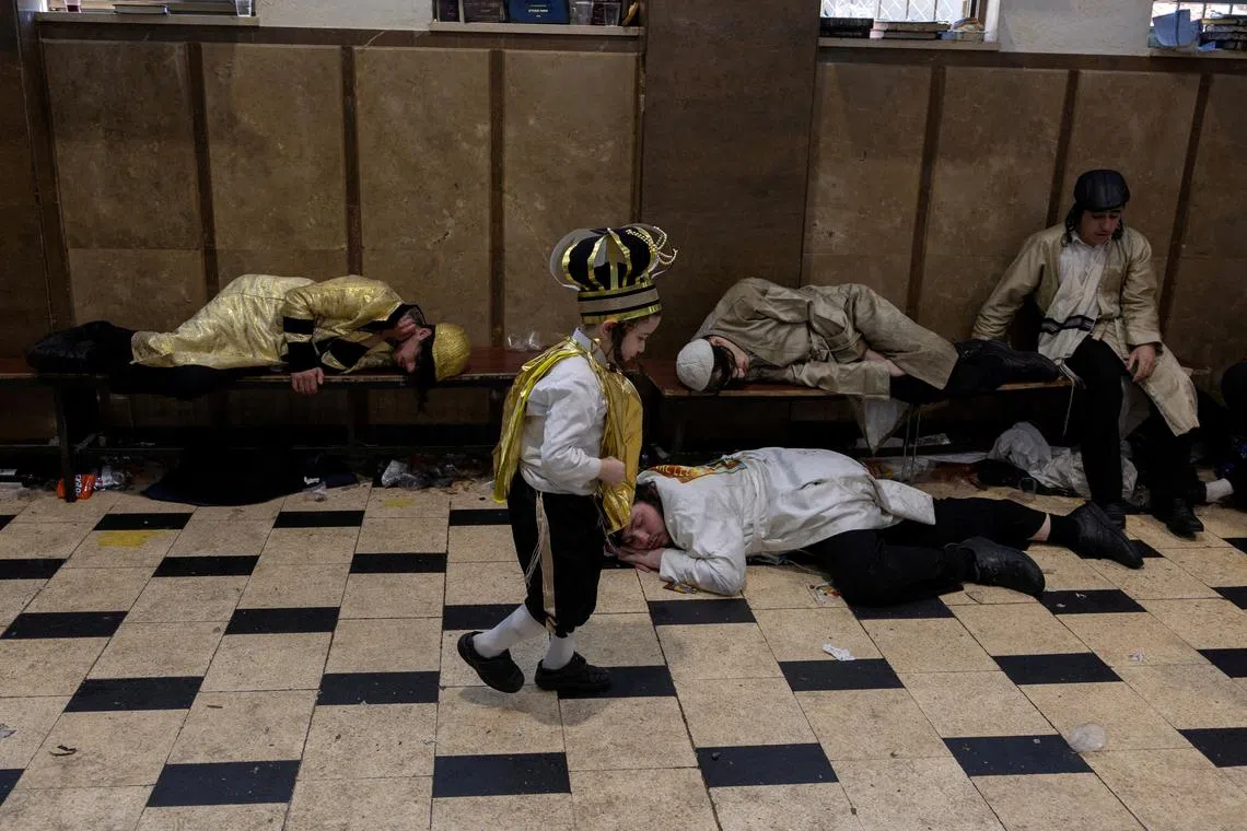 An Ultra-Orthodox Jewish boy dressed in costume walking during a feast in a synagogue marking the Jewish holiday of Purim, in the Mea Shearim neighbourhood of Jerusalem, Mar 16, 2025.