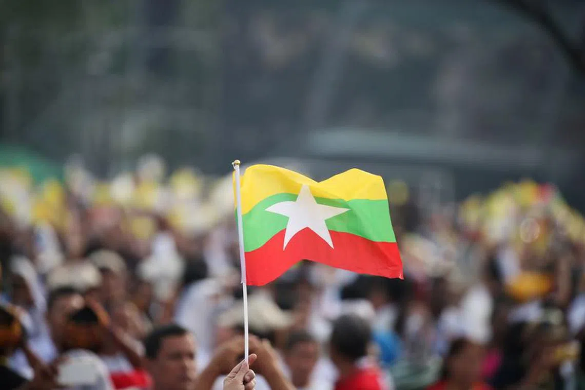 FILE PHOTO: A Catholic faithful waves a Myanmar flag as Pope Francis arrives to lead a mass at Kyite Ka San Football Stadium in Yangon, Myanmar November 29, 2017. REUTERS/Soe Zeya Tun