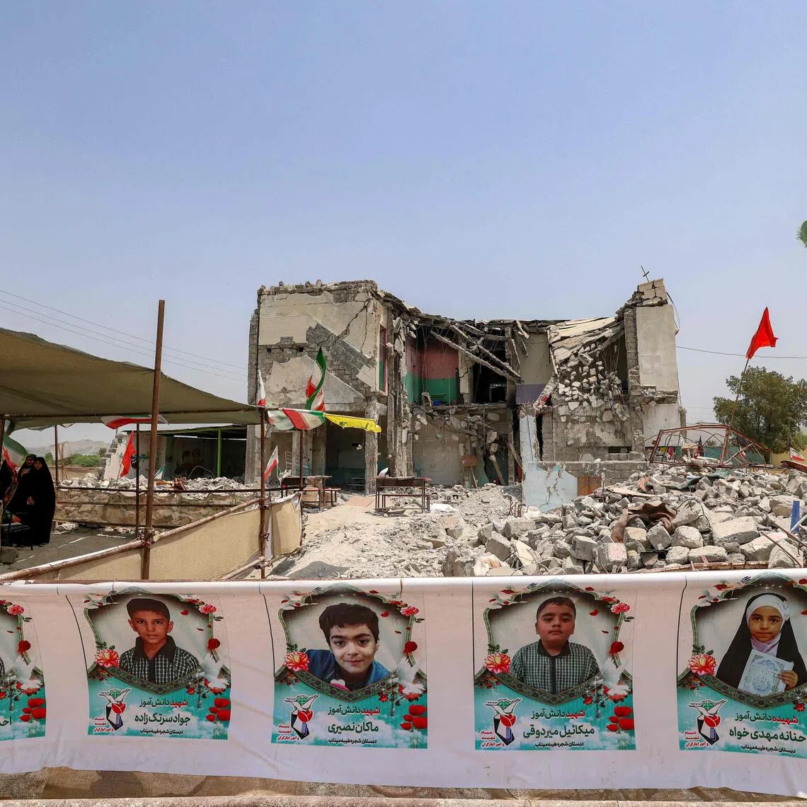 The Shajareh Tayebeh primary school which has remained largely in ruins, its collapsed walls and twisted steel now surrounded by portraits of the children killed.