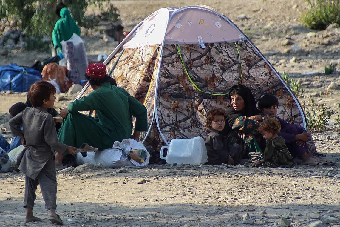 People sit outside a makeshift shelter after the earthquake in the Sawkay district of Afghanistan's Kunar province on Sept 8.